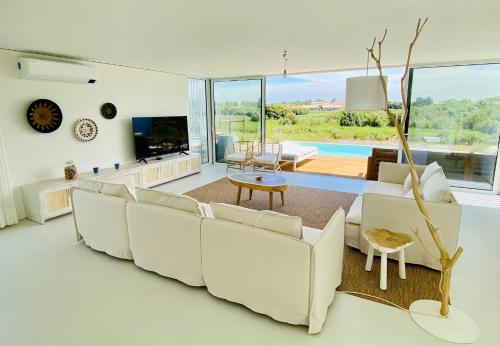 孔波尔塔Villa Possanco, Comporta beach villa的客厅配有白色沙发和电视