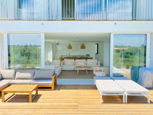孔波尔塔Villa Possanco, Comporta beach villa的客厅配有白色家具和桌子