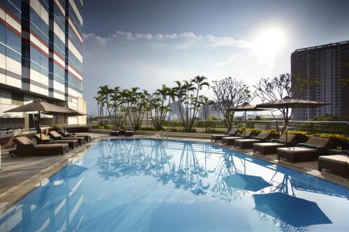 河内河内美利亚酒店的一座带躺椅的游泳池和一座建筑