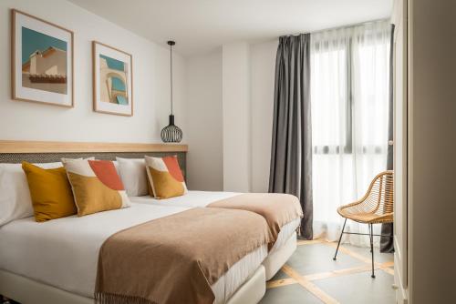 加的斯BYPILLOW La Sal的酒店客房设有两张床和窗户。