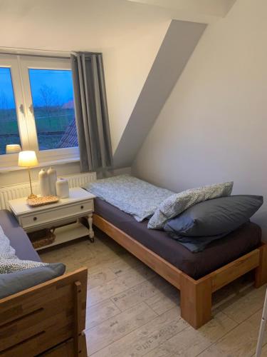 埃姆登Lüttes Huus的一间卧室设有一张床和一个窗口