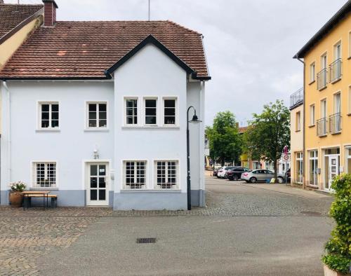圣温德尔Ferienwohnung Villa Wolke的街上的白色建筑,有停车的汽车