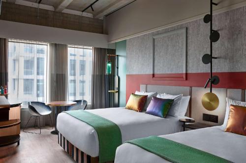 奥克兰QT Auckland的酒店客房配有两张床和一张书桌