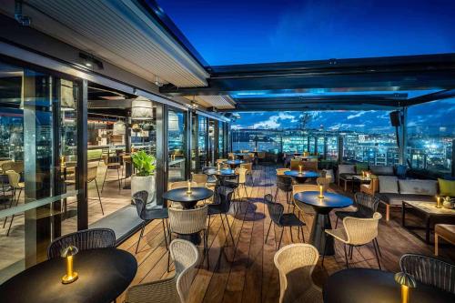 奥克兰QT Auckland的一间带桌椅的市景餐厅