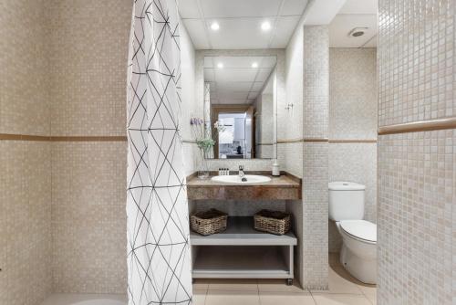 巴塞罗那Lodging Apartments Liceu 11的一间带水槽、卫生间和镜子的浴室