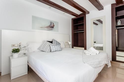 巴塞罗那Lodging Apartments Liceu 11的白色的卧室配有一张白色的大床和镜子