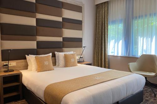 阿姆斯特丹XO蓝色广场酒店的一间卧室配有一张带条纹床头板的大床