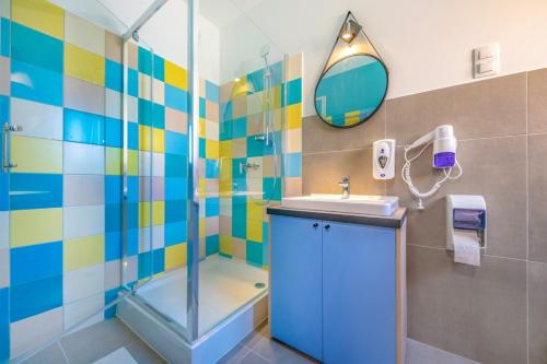 迈泽克韦什德Zsóry Liget Camping & Resort的带淋浴、盥洗盆和镜子的浴室