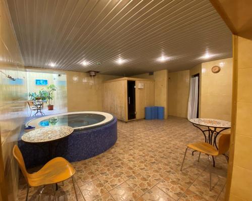 凯代尼艾Hotel-Restaurant Smilga的客房设有带2张桌子和椅子的按摩浴缸。