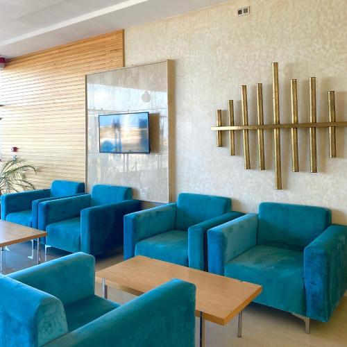 Douar DraoudHotel Atlantis Mazagan的一间设有蓝色椅子和桌子的等候室