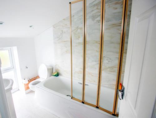 Wolsingham布朗马酒店的白色的浴室设有浴缸和卫生间。