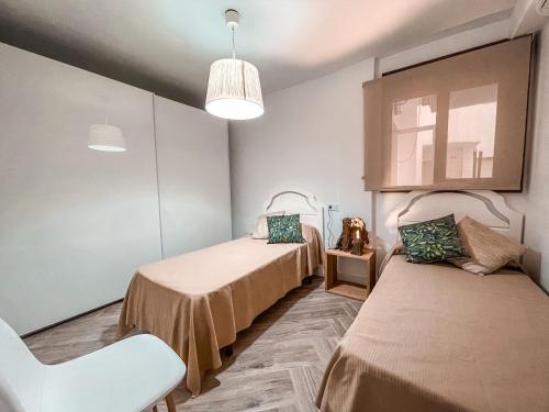 福恩吉罗拉Luxury Family Holiday Homes - Sol Playa Fuengirola的一间医院间,配有两张床和椅子