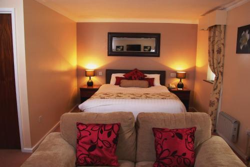 莫尔德博福特公园酒店的一间卧室配有一张床和一张带两个枕头的沙发