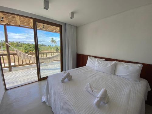 佩德拉斯港Casa Seriguela - Praia do Patacho - Rota Ecológica dos Milagres的卧室配有带白色床单的床铺和大窗户