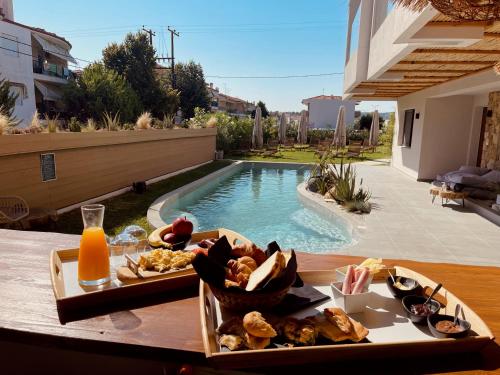 卡利塞亚-豪客迪克斯Olvion Luxury Living的游泳池旁桌子上的一盘食物