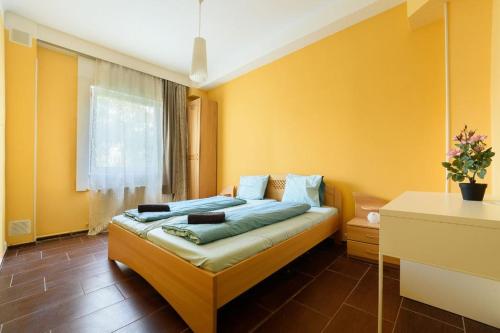 布达佩斯Downtown Buda Homes Relax的一间卧室设有一张黄色墙壁的床