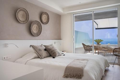 库姆布勒德尔索尔Infinity Horizon Apartment - Costa Blanca的白色卧室配有一张大床和一张桌子