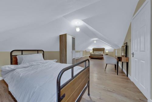 达特福德Suites by Rehoboth - Makeba Suite - Dartford的一间卧室配有一张床、一张桌子和一把椅子