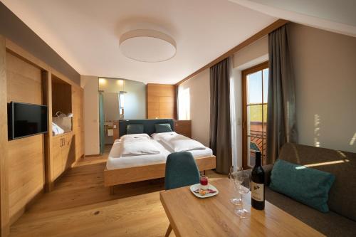 延纳斯多夫Hotel Panoramahof Loipersdorf的酒店客房配有一张床铺和一张桌子。