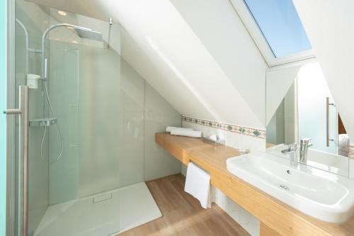 延纳斯多夫Hotel Panoramahof Loipersdorf的一间带玻璃淋浴和水槽的浴室
