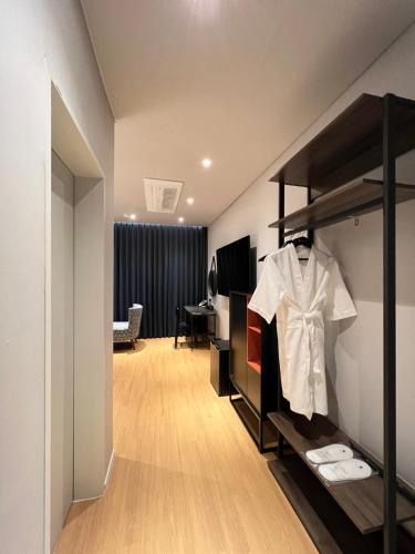 昌原市Jinhae Intercity Hotel的一间房间,配有衣柜和架子上的衬衫