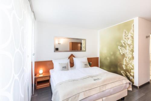 门兴格拉德巴赫Novum Hotel Freiraum的卧室配有白色的床和镜子