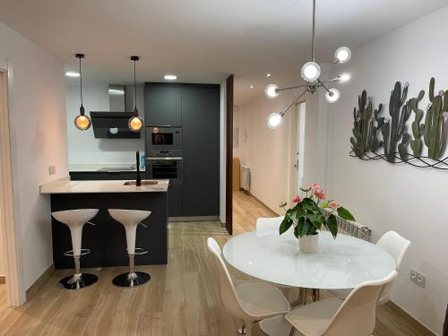 格拉纳达Aixa Granada的厨房以及带白色桌椅的用餐室。