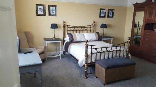 锡斯凯尔Ideally located Cumbrian home with stunning views的一间卧室配有一张床、一把椅子和一张沙发