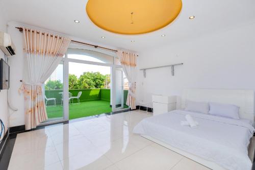 头顿Villa Hai An的白色的卧室设有床和大窗户