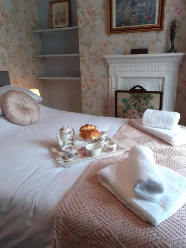 特尔福德Rose Cottage的一张白色的床,上面放着一盘食物