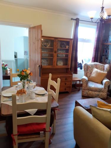 特尔福德Rose Cottage的一间带桌椅和沙发的用餐室