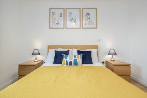 沃金Cloud9SA at The Park Heights Woking的一间卧室配有一张带两盏灯的大型黄色床。