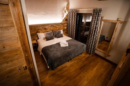布勒伊-切尔维尼亚Chalet Hotel Dragon的一间小卧室,配有一张床和镜子