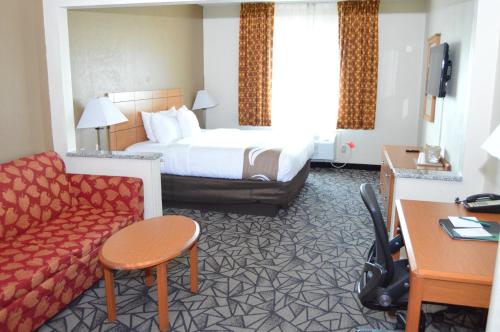 克拉尔维尔Quality Inn Coralville - Iowa River Landing的酒店客房,配有床和沙发