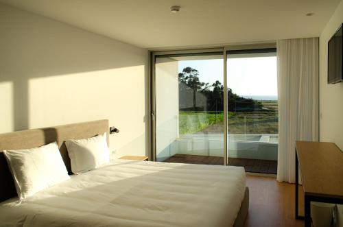 埃斯波森迪Marinhas Bed & Breakfast的一间卧室设有一张大床和一个大窗户