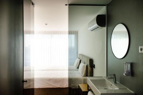 埃斯波森迪Marinhas Bed & Breakfast的浴室设有床、水槽和镜子