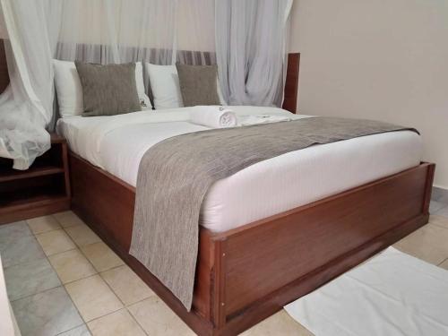 KakamegaLogmma Regency Hotel的一张木框大床