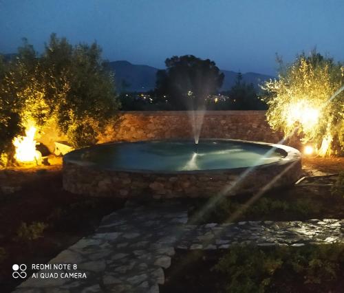 加拉希德松Villa in the Olive Trees的夜晚在院子里的喷泉里,灯光照亮