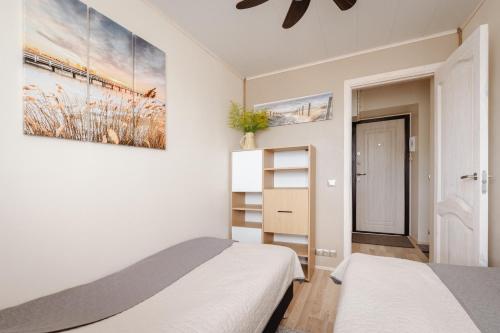 哈普萨卢Kuuse 4 Apartment with 2 bedrooms的一间卧室设有两张床,墙上挂着一幅画