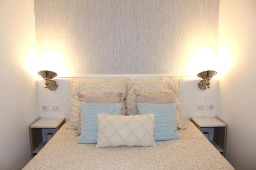 阿尔宗L'Aigue-Marine emplacement parfait, parking privé的一间卧室配有一张带两个灯的床