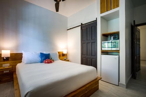 珀拉什奇亚The Sea Glass Inn的卧室配有一张白色大床和一台冰箱