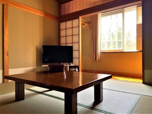 南鱼沼市Koguriyama Sanso - Vacation STAY 16071v的客厅配有木桌和电视。