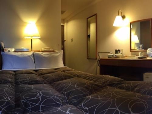 福井Az Inn Fukui - Vacation STAY 65940v的一张大床,位于酒店带书桌的客房内