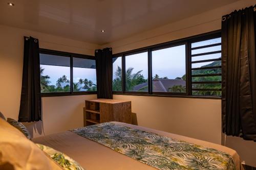 波拉波拉Hidden Villas by Matira Beach的一间卧室设有一张床和大窗户