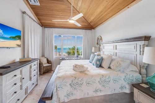 宝藏岩礁Bahama Beach Club的一间卧室配有一张床、一张书桌和一个窗户。