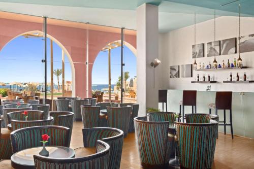 库塞尔库塞尔丽笙度假酒店的一间带椅子的餐厅和一间享有美景的酒吧