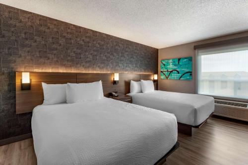 埃德蒙顿西方华美达酒店的酒店客房设有两张床和窗户。
