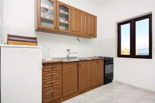 博格莫耶Apartments by the sea Cove Bristova, Hvar - 5716的一个带木制橱柜和水槽的厨房