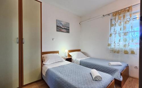 弗班吉Apartments by the sea Basina, Hvar - 5699的小型客房 - 带2张床和窗户
