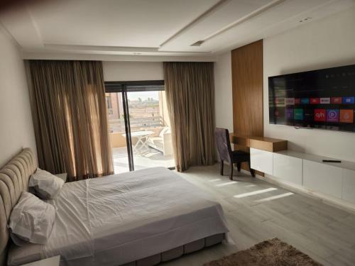 马拉喀什Marrakech Villa du Golfeur familles uniquement的一间卧室配有一张床、一台电视和一张书桌